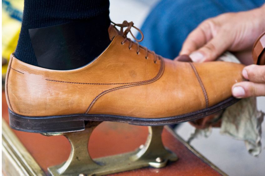 Shoe Shine Service by webphotographeer from Getty Images Signature Close up view of man's foot on shoe shine char base with tan shoe being polished