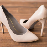 by Izzy's Images Close up of women's light tan high heel shoes shinning after polish