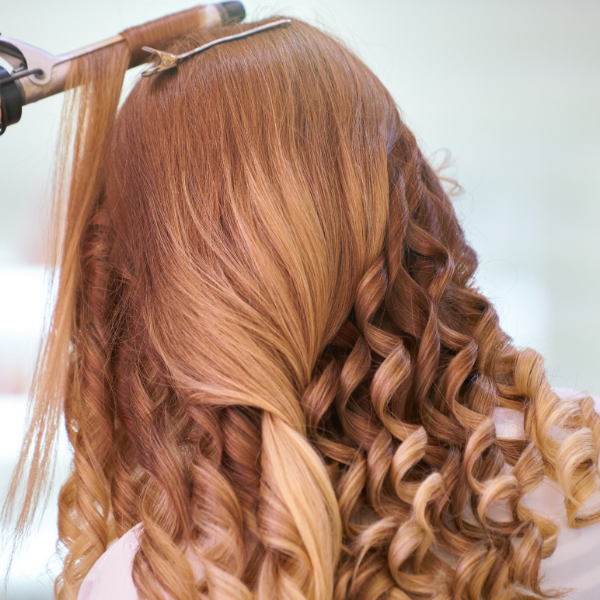 by Engin Akyurt from Pexels Young women with long ted hair rear view getting a stylish haircut with curld
