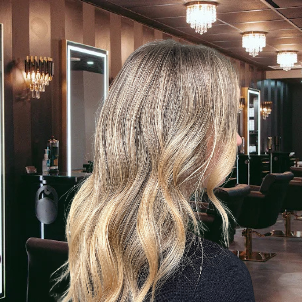 Salon Baci client with rear view of beautiful long blonde hair after have a dimensional hair coloring service.
