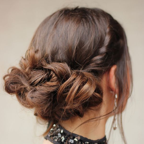 Image of a women from rear view after styling a Braided Hairstyle the Fishtail Braid light brown hair with a single horizontal braid and a fishtail gather at the back.