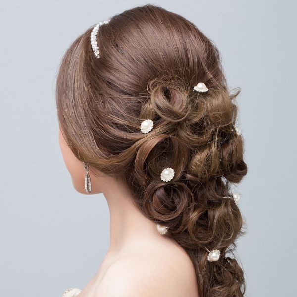 Sample Braided Hair style a French Braid. Rear view of young women with light brown hair and French braid with white beads added for styling.