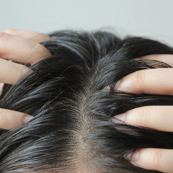 Close up of women with black hair messaging her scalp