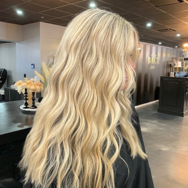 Salon Baci client with long blonde hair and highlighted afte a coloring servie