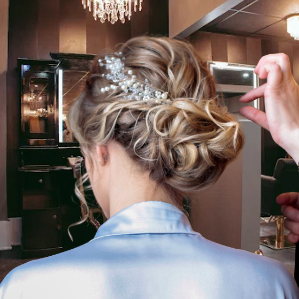 Salon Baci image of women getting final touches on her new hairstyling with updo.